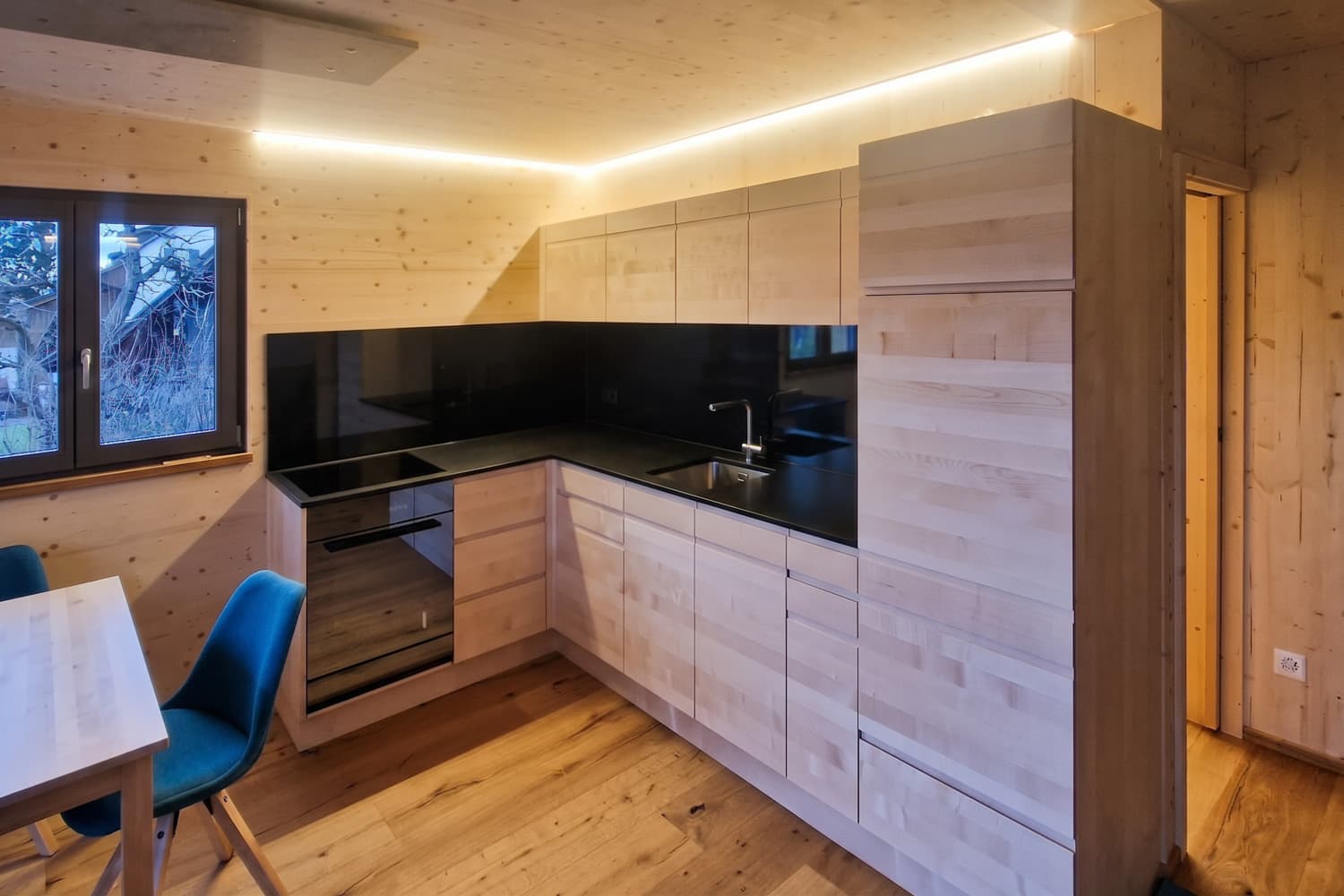 ZINIPI 3-ModulHaus in Gallenkirch AG: Küche in Holz mit dunkler Abdeckung