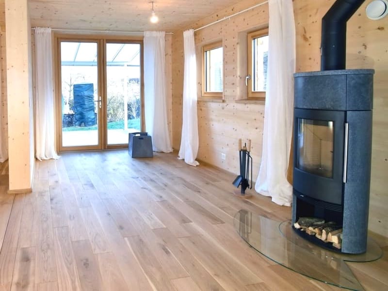 ZINIPI 2-ModulHaus in Opfertshofen SH: Wohnzimmer mit Stückholzofen und Fenstertür zur Terrasse
